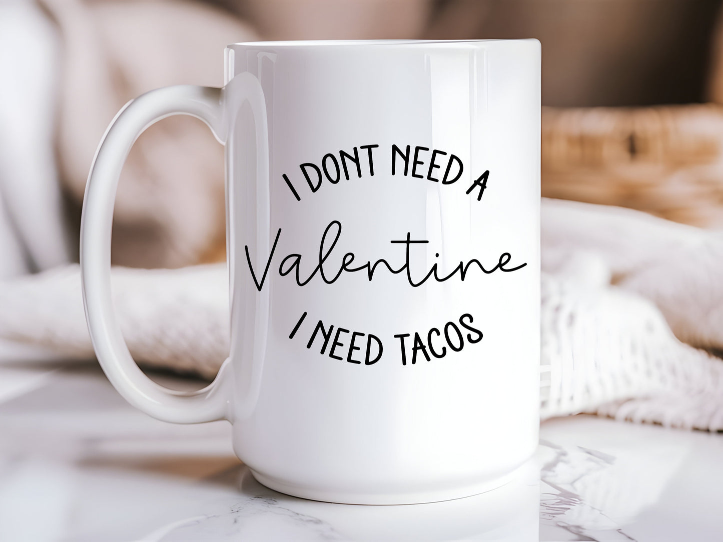 White mug with text 'I don't need a Valentine, I need tacos' on a marble surface.