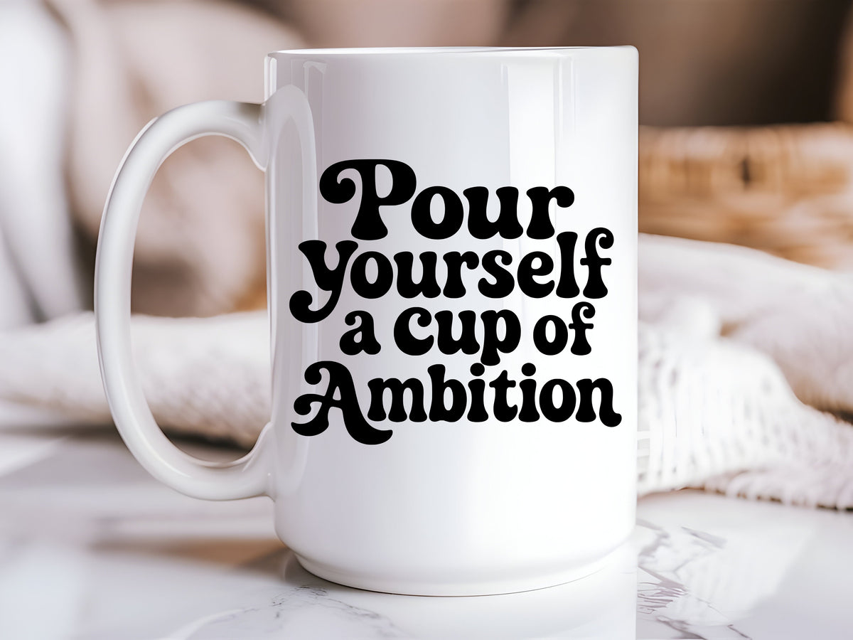 White 15oz ceramic coffee mug featuring Pour Yourself a Cup of Ambition in bold black retro lettering.